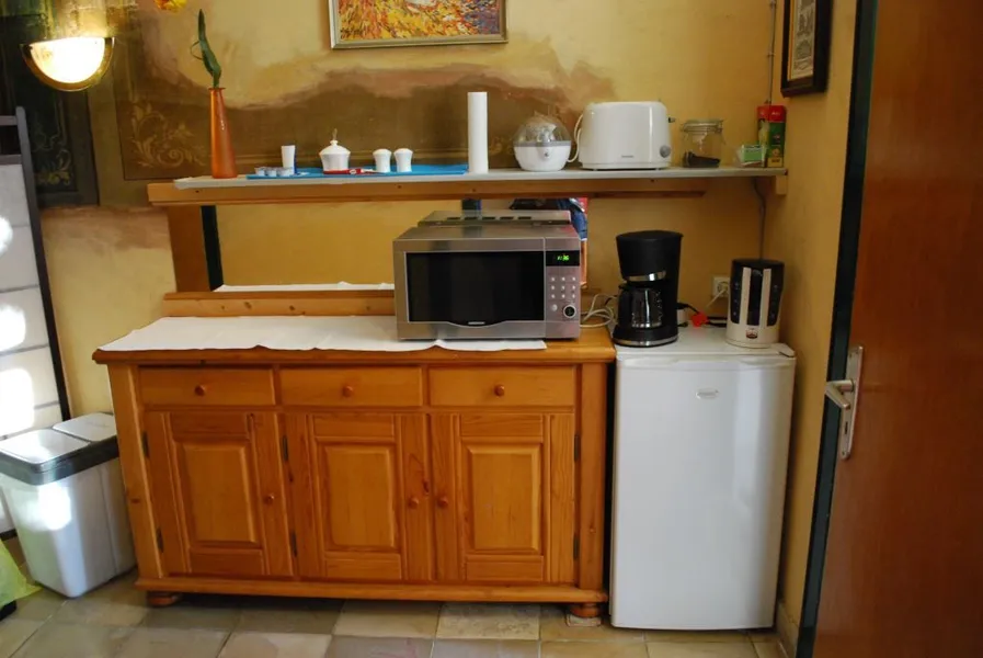 Küche mit Mikrowelle, Kaffeemaschine, Toaster und Kühlschrank